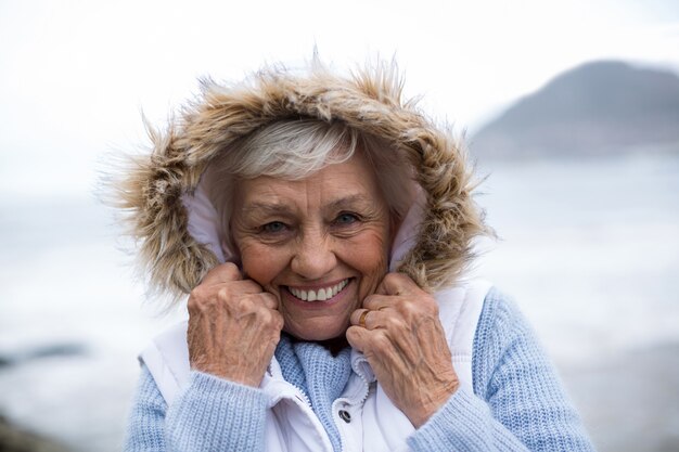 Portret dat van hogere vrouw zich op het strand bevindt