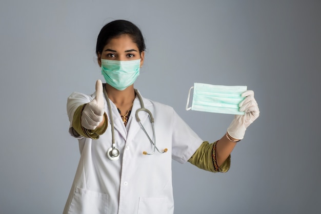 Portret dat van jonge vrouw arts geopend medisch masker toont. quarantainemaatregelen en levensreddend concept