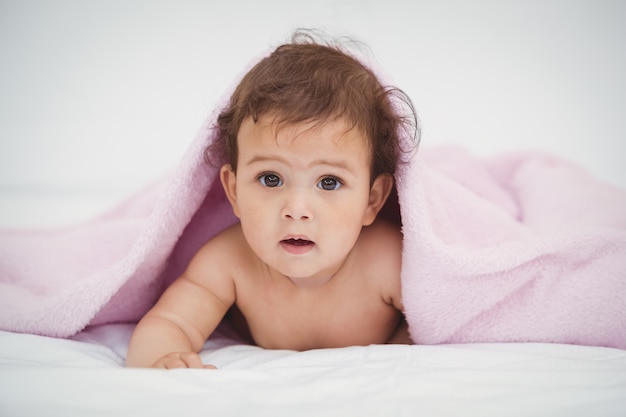 Portret dat van leuke baby onder deken ligt
