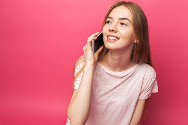 Portret dat van vrolijk mooi meisje die op telefoon spreken, grappig genoeg weg kijken