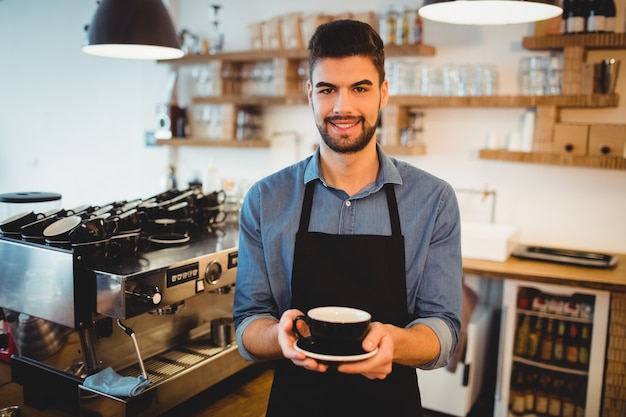 Portret die van de mens zich met een kop van koffie in bureaucafetaria bevinden