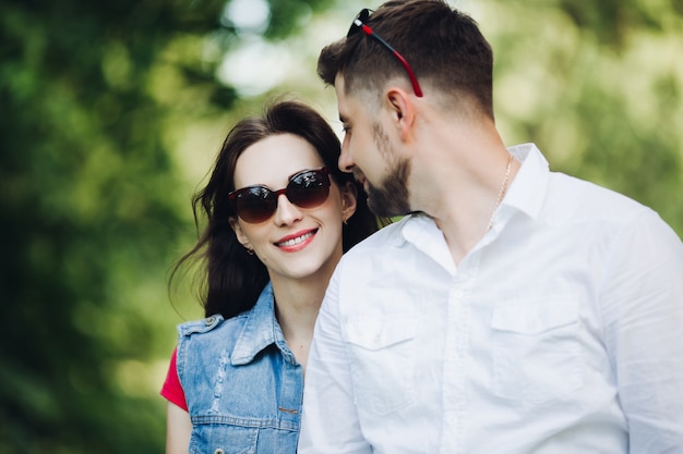 Portret die van jong gelukkig paar in liefde, en in tuin glimlachen omhelzen