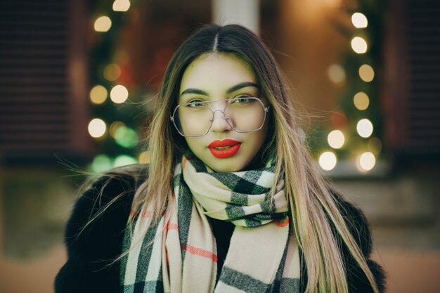 Portret die van jonge gelukkige vrouw de winterkleren in Franse stijl dragen, die in straten stellen