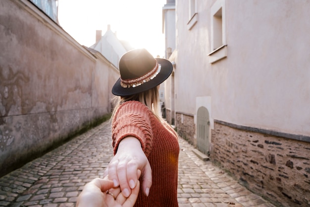 Portret die van mooie vrouw zich in de straat bevinden die in openlucht iemands hand houden