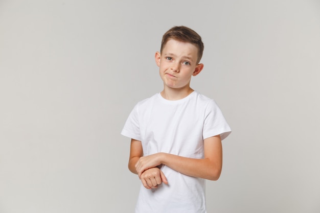 Portret die van verstoorde jongen zich met die wapens bevinden over witte achtergrond worden geïsoleerd