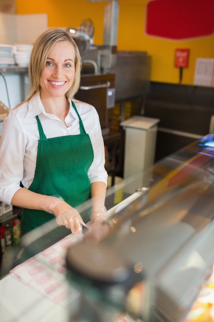 Portret die van vrouwelijke werknemer bij teller in bakkerij werken