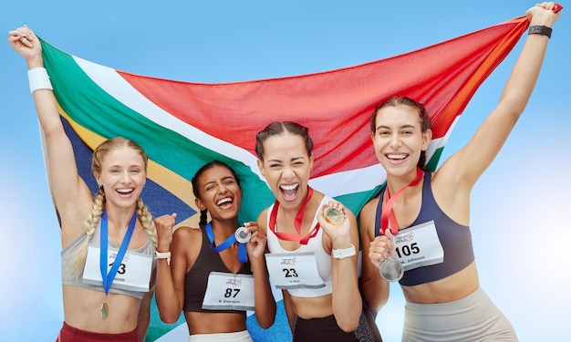 Portret diverse groep vrouwelijke olympische atleten met winnaarsmedailles en Afrikaanse vlag Gelukkige en trotse kampioenen van Zuid-Afrika Het winnen van een medaille voor uw land is een geweldige prestatie