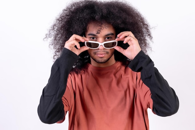 Portret dragen van een zonnebril en kijken naar de camera Jonge jongen met afro haar op witte achtergrond