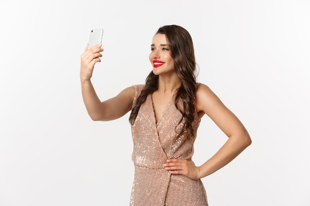 portret expressieve jonge vrouw in elegante jurk selfie te nemen