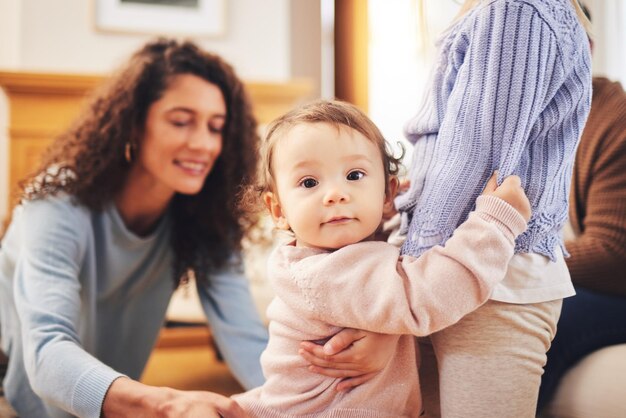 Portret familie en baby met wellness-ondersteuning en geluk thuis ontspannen en plezier Gezicht kind en baby met een vrolijke glimlach en quality time met hechtende ouders en peuter in de woonkamer