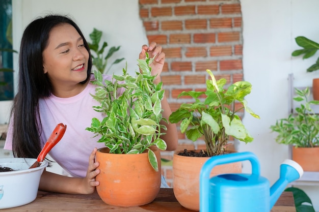 Portret gelukkig jong meisje met groene planten thuis Aziatisch meisje