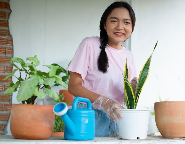 Portret gelukkig jong meisje plant een boom in pot thuis Aziatisch meisje