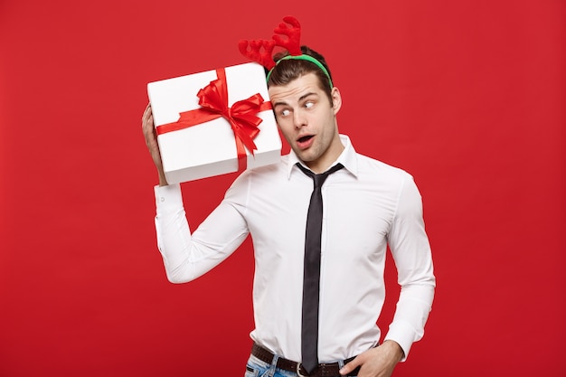 portret gelukkig Santa christmas zakenman spannende met zijn geschenk op rode achtergrond.