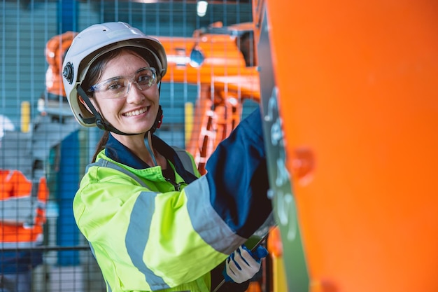 Portret gelukkige vrouw werknemer met robot assemblage machine in moderne metaalindustrie fabriek