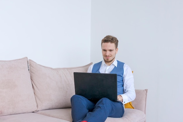 Portret gelukkige zakenman met baard in blauw pak zittend in hotelkamer