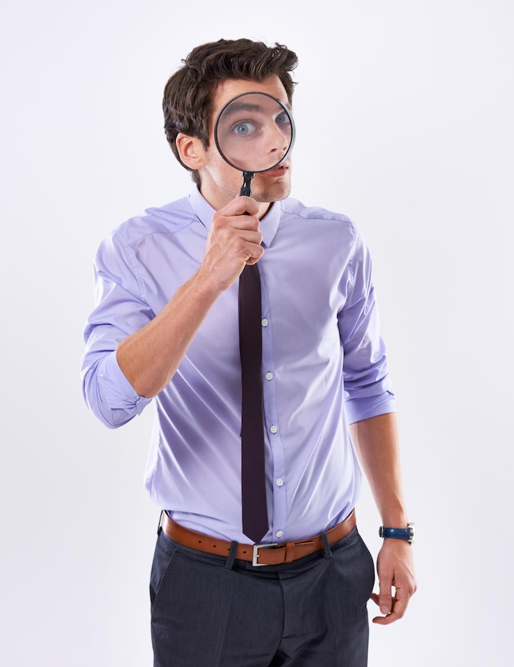 Foto portret gezicht en zakenman met vergrootglas onderzoeker en audit bij bedrijf op witte studio achtergrond oog mannelijke werknemer en pi met naleving en eerlijke handel bewijs of informatie