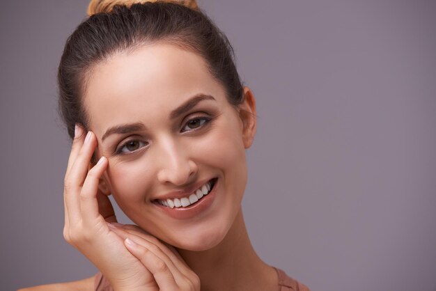 Portret glimlach en schoonheid met vrouw op ruimte in studio voor huidverzorging wellness of natuurlijke cosmetica Gezicht esthetiek en mockup met gelukkige jonge persoon op grijze achtergrond voor natuurlijke dermatologie