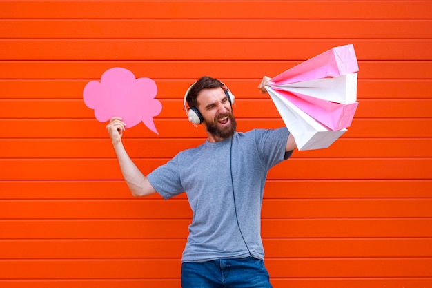 Portret hipster man geniet van grote verkopen tijdens het winkelen