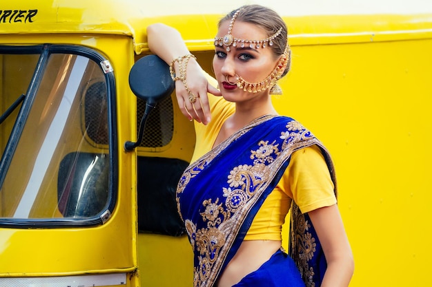 Portret Indiase mooie blanke vrouw in traditionele blauwe dress.hindu model met gouden kundan sieraden set bindi oorbellen en neusring piercing nath fashion fotoshoot op Srilankaanse straatmarkt