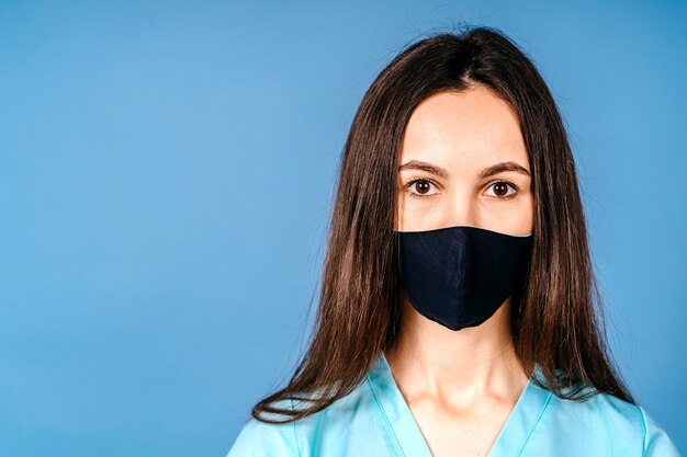 Portret jonge artsenvrouwen droevige verpleegster die het masker draagt en kijkt