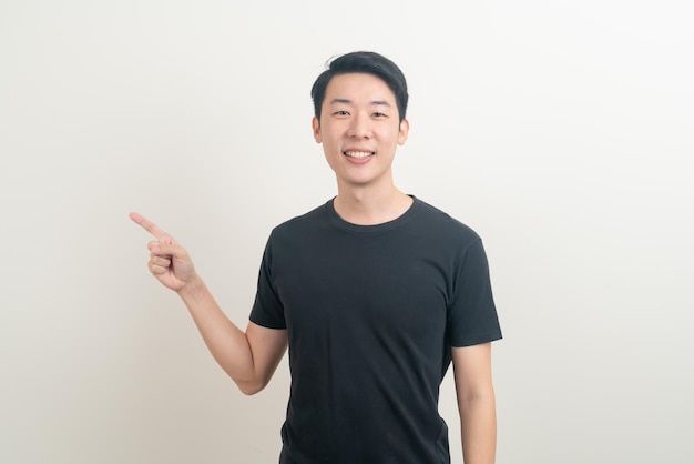 portret jonge Aziatische man met de hand wijzend of presenterend op een witte achtergrond