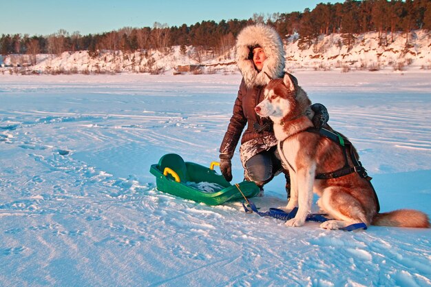 Portret jonge eigenaar en husky hond Schattig meisje op wandeling met rode Siberische Husky hond op zonnige dag