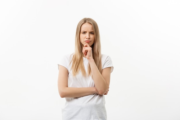 Portret jonge ernstige blanke vrouw denken aan iets.