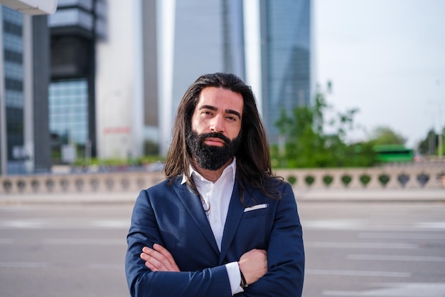 Portret jonge man met baard en lang haar gekleed in pak in financiële zone