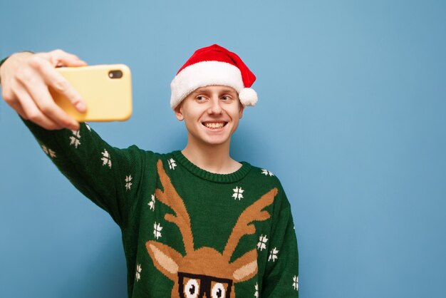 portret jonge man met kerstmuts met telefoon