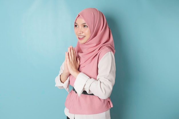 Portret jonge mooie moslimvrouw met een roze hijab Eid Mubarak-groet