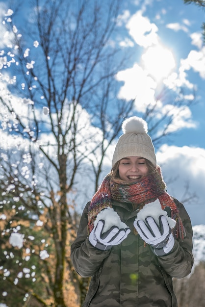 Portret Jonge mooie vrouw die van en met sneeuw in de winter geniet speelt