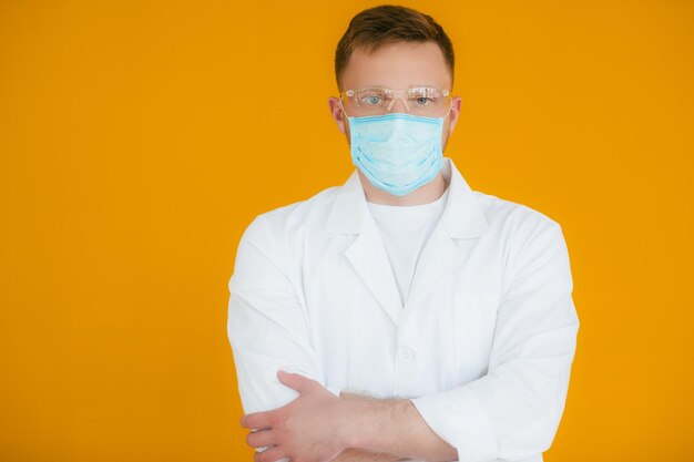 Portret jonge uitgeputte arts met blauw medisch masker op gezicht Preventie van coronavirus nCov19