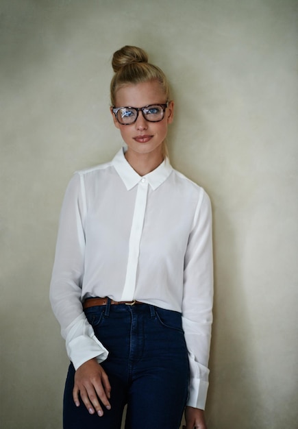 Foto portret jonge vrouw en mode in blouse met bril en haar in een broodje vrouwelijk model met blonde up doen met slimme casual stijl kleding in studio als kleine ondernemer