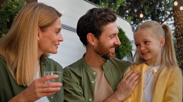 Foto portret kaukasische gelukkige familie buiten in de buurt van huis camping lunchen picknick fruit drinken