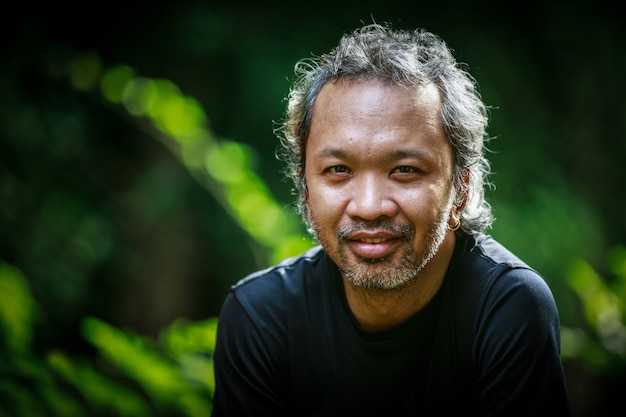 Portret lachende Aziatische oude man op zoek naar camera