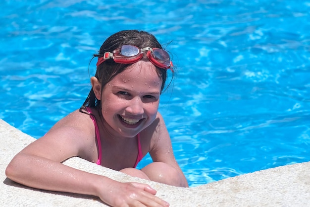 Portret lachende meisje in zwembad in zwembril Zomer reizen hotel vakantie of klassen