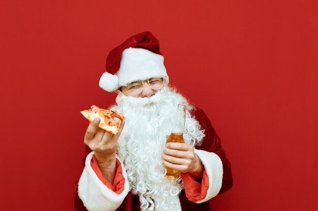 Portret man verkleed als kerstman met pizza en bier