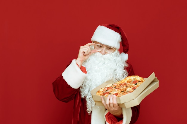 Portret man verkleed als kerstman met pizza