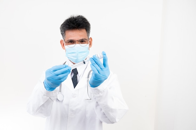 Portret Mannelijke arts die een spuit en een vaccinfles met geïsoleerde oppervlakte houdt