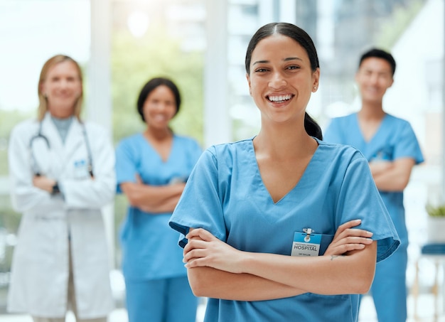 Portret medisch en een vrouwelijke verpleegster armen gekruist staande met haar team in het ziekenhuis voor gezondheidszorg Leiderschapsgeneeskunde en teamwerk met een vrouwelijke gezondheidswerker in een kliniek voor behandeling