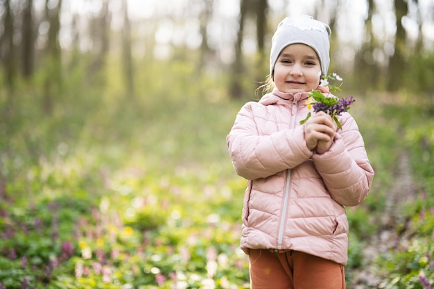 Portret meisje met boeket bloemen op zonnig bos Outdoor lente leisure concept