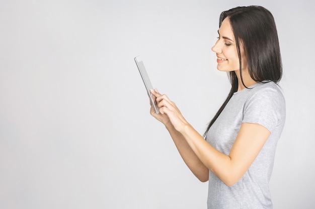 Portret met exemplaar ruimte lege plaats van vrouw in toevallig hebbend tablet in handen die het scherm bekijken dat op witte achtergrond wordt geïsoleerd.