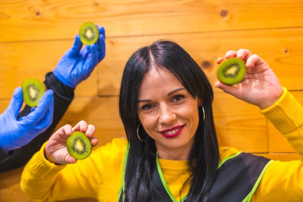 Portret met veel kiwi's in de hand van een brunette Kaukasisch fruitmeisje