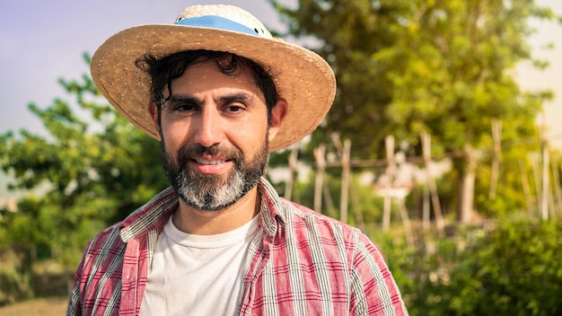 Portret moderne bebaarde boer man kijken camera glimlach en staat in de verte