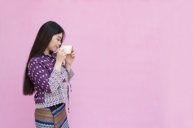 Portret mooi Aziatisch meisje in traditionele Thaise kleding en het houden van koffiekopje