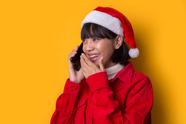 Portret mooie aziatische vrouwen dragen kerstmuts met mobiele telefoon