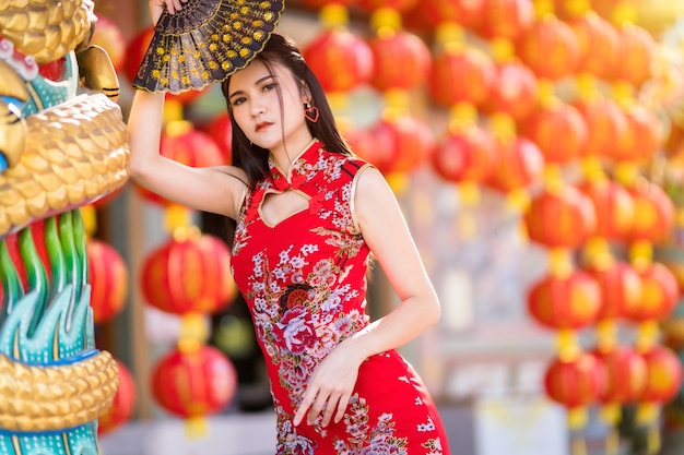 Portret mooie glimlach Aziatische jonge vrouw, gekleed in rode traditionele Chinese cheongsam