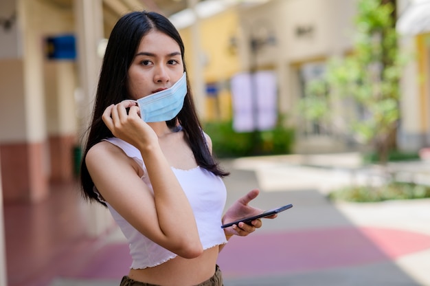 Portret mooie jonge aziatische vrouw met masker in veel actie voor bescherming tegen coronavirus of covid19