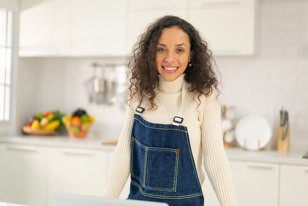 Portret mooie Latijnse vrouw in keuken