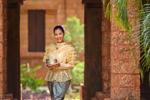 Portret mooie vrouw in Songkran-festival met Thais traditioneel kostuum in de tempel met waterkom en glimlach Thailand-cultuur met waterfestival